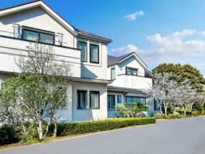 白い外壁の邸宅と庭木